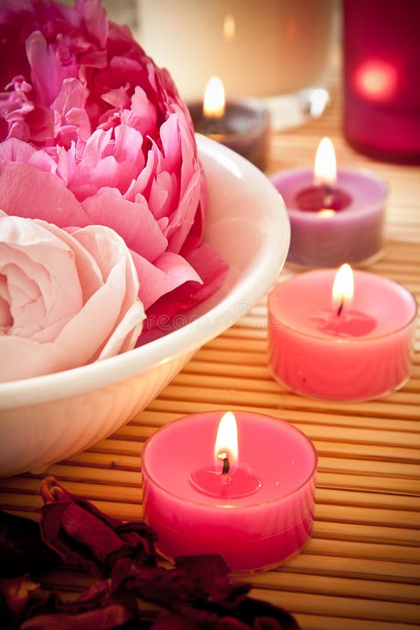 Mísa plná krásné růžové aromaterapie květiny, svíčky.