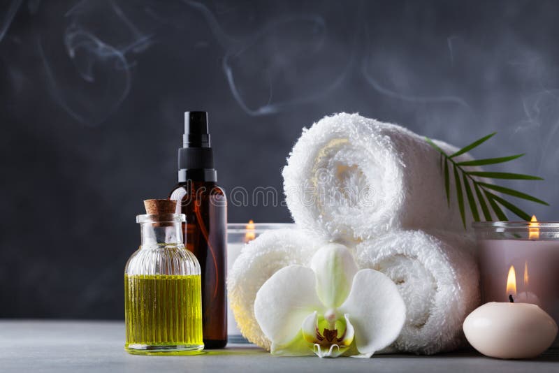 Aromatherapy, zdrój, piękna traktowanie i wellness tło z masażu olejem, storczykowi kwiaty, ręczniki, kosmetyczni produkty