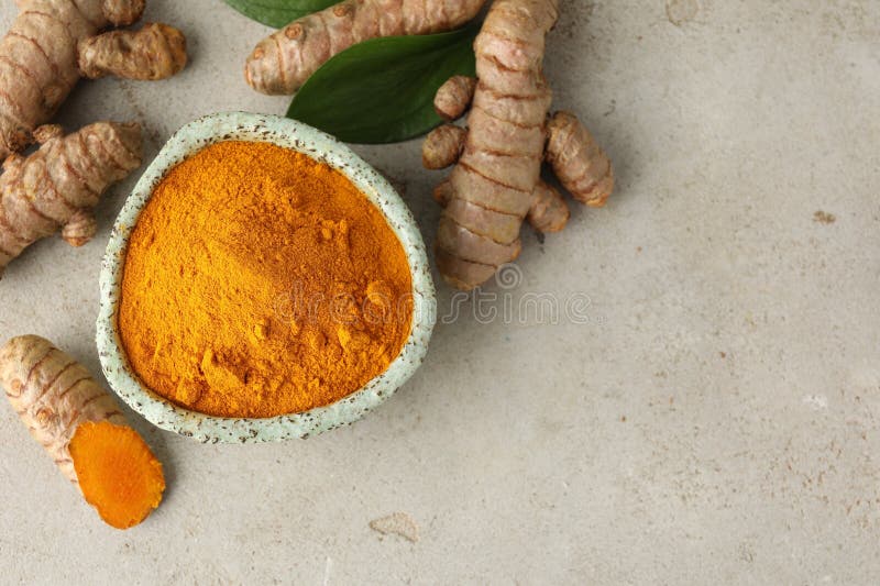 Aromatic turmeric powder in bowl fresh roots and leaves on light grey table flat lay space for text stock afbeelding