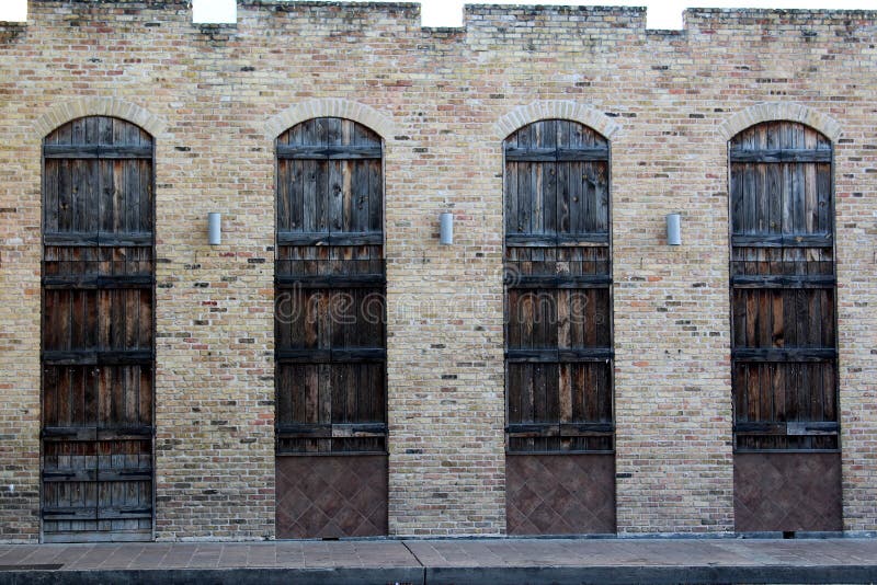 Arquitectura de un bonito edificio antiguo de ladrillo con puertas de madera acristalada y farolillos entre cada uno imagen de archivo Arquitectura de un bonito edificio antiguo de ladrillo con puertas de madera acristalada y farolillos entre cada uno imagen de archivo