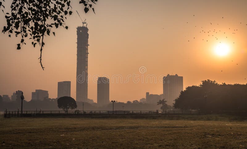 Arquitetura da cidade no nascer do sol em uma manhã enevoada do inverno como visto de Kolkata maidan fotografia de stock royalty free Arquitetura da cidade no nascer do sol em uma manhã enevoada do inverno como visto de Kolkata maidan fotografia de stock royalty free