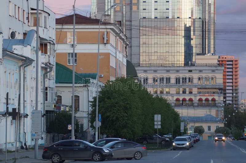 Arquitetura da cidade: vista da rua de Pushkin O por do sol colore o céu e o vidro das construções foto de stock Arquitetura da cidade: vista da rua de Pushkin O por do sol colore o céu e o vidro das construções foto de stock
