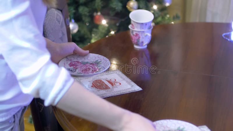 Arrangeant la table pendant le temps de thé avec des décorations de Noël sur le fond - vue de plan rapproché banque de vidéos
