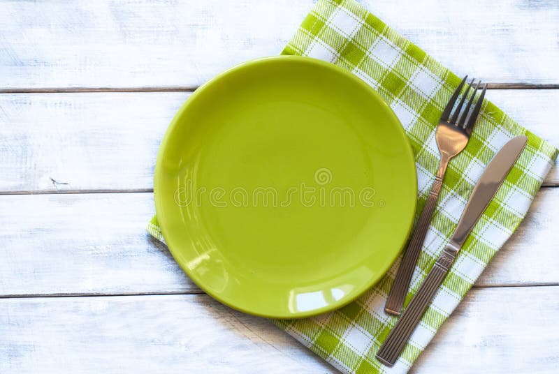 Spring table setting with green plate over wooden table background. View from above with copy space. Spring table setting with green plate over wooden table background. View from above with copy space