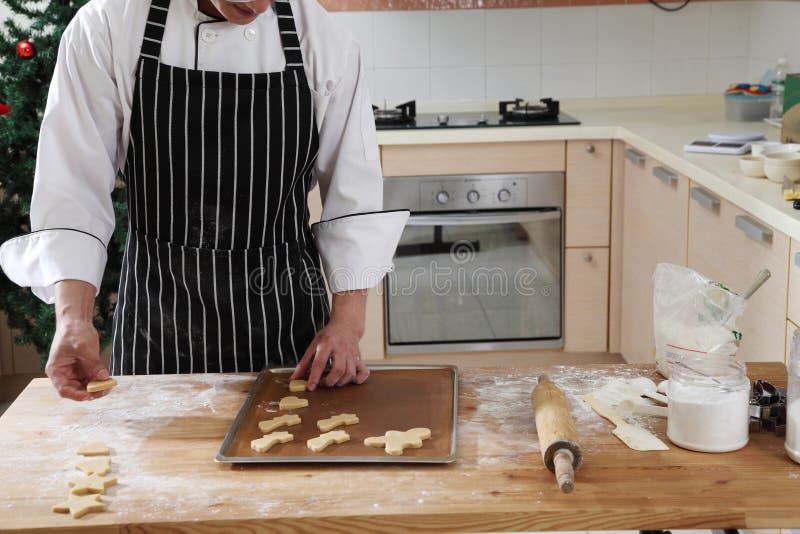 Chef arranging christmas cookies to bake. Chef arranging christmas cookies to bake