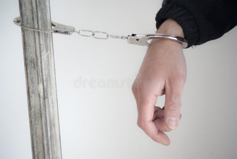 Close-up. Arrestant op één hand xpX de handboeien om:doen die stock afbeelding Close-up. Arrestant op één hand xpX de handboeien om:doen die stock afbeelding