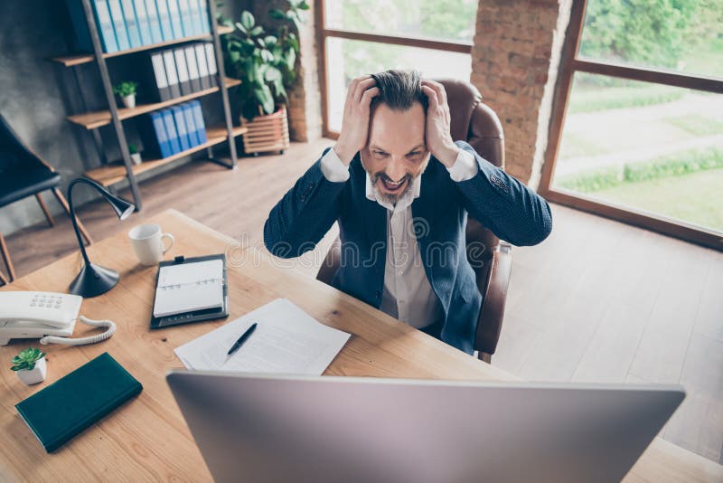 Arriba el retrato de vista en ángulo alto de su hermoso loco apuesto y frustrado hombre miserable monitoreando el ciberespacio imagen de archivo