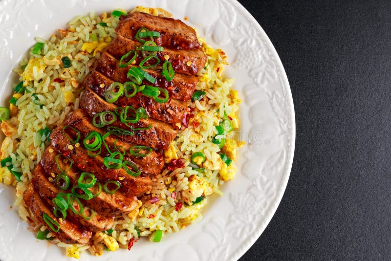 Arroz fritado do ovo do estilo chinês com a faixa cortada da carne de porco imagem de stock Arroz fritado do ovo do estilo chinês com a faixa cortada da carne de porco imagem de stock