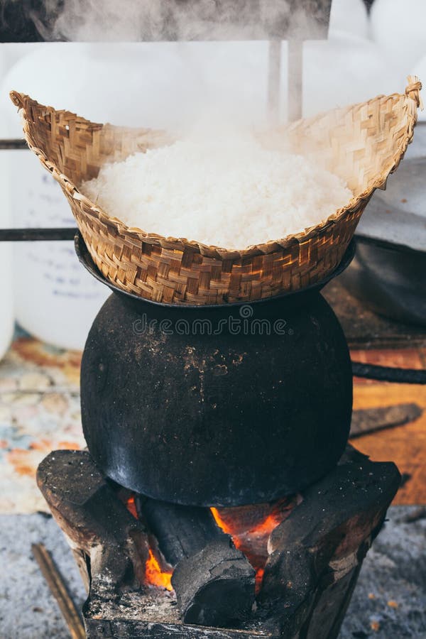 Arroz laotian branco do vapor que cozinha no fogão ardente de madeira em Luang Prabang, Laos foto de stock royalty free Arroz laotian branco do vapor que cozinha no fogão ardente de madeira em Luang Prabang, Laos foto de stock royalty free