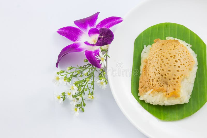 Arroz pegajoso con natillas cocidas al vapor en las hojas del plátano y plato con la flor de la orquídea fotografía de archivo libre de regalías Arroz pegajoso con natillas cocidas al vapor en las hojas del plátano y plato con la flor de la orquídea fotografía de archivo libre de regalías