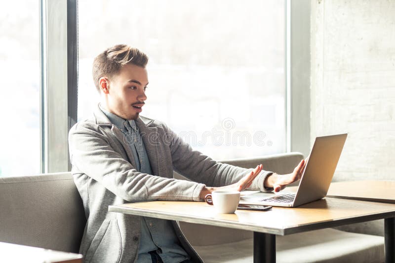 Arrêt! Le portrait de vue de côté du jeune homme d'affaires effrayé émotif dans le blazer gris se reposent en café et crient image stock