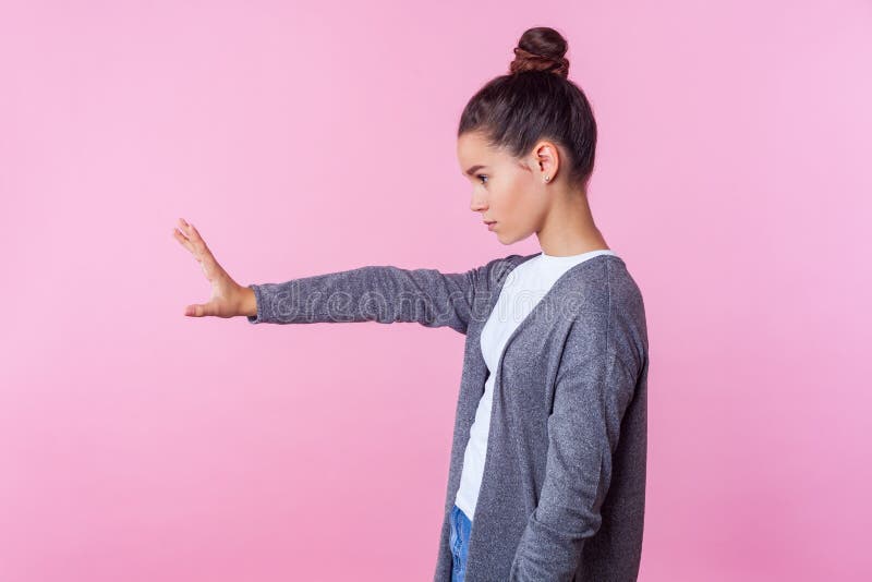 Arrêtez! Vue latérale d'une adolescente stricte debout avec la main levée montrant un geste d'interdiction bloquant avec la paum images stock