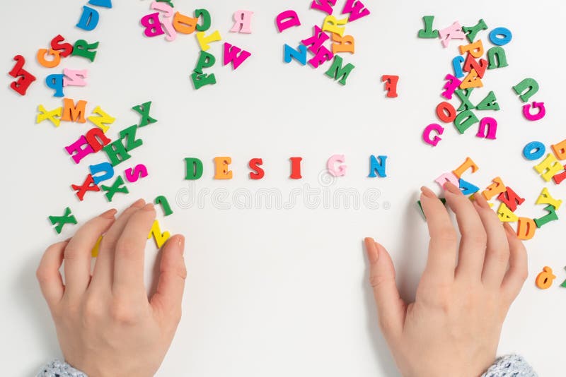 Art and architecture. Female hands lay out of colorful letters the word design royalty free stock photography