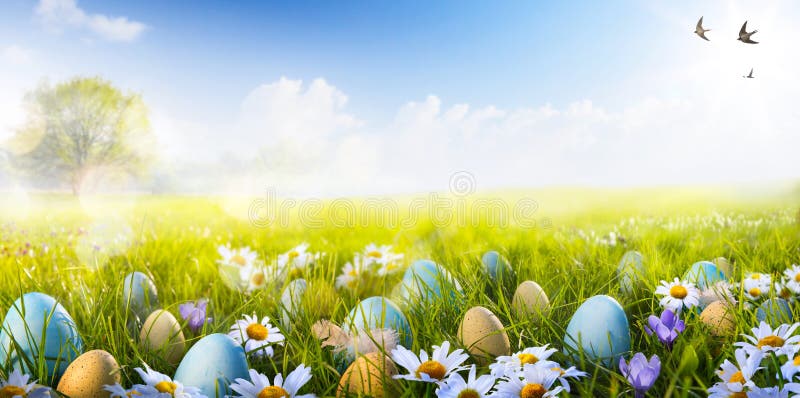 Barevné Velikonoční vajíčka zdobená květy v trávě na modré obloze na pozadí.