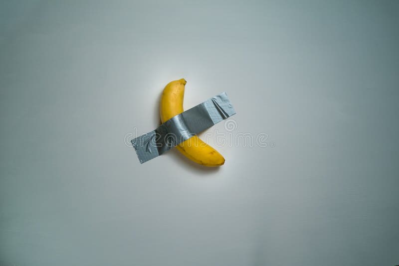 Banana Taped on the Wall by Scotch Tape. Art Concept. Stock Photo