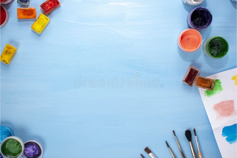 Art supplies: watercolor, acrylic, brushes and palette on a blue background. Flat lay, top view. Desk artist royalty free stock photo