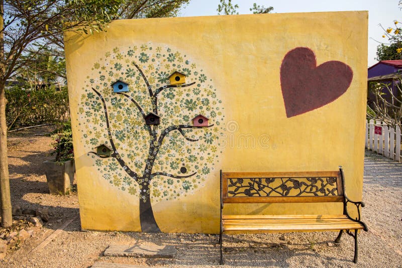 Art Tree Painting On Cement Wall And Yellow Park Bench Stock Image