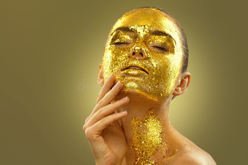 Arte de moda piel dorada mujer rostro retrato. modelo de chica con lámina de oro rota en la piel. glamour brillante maquillaje pro