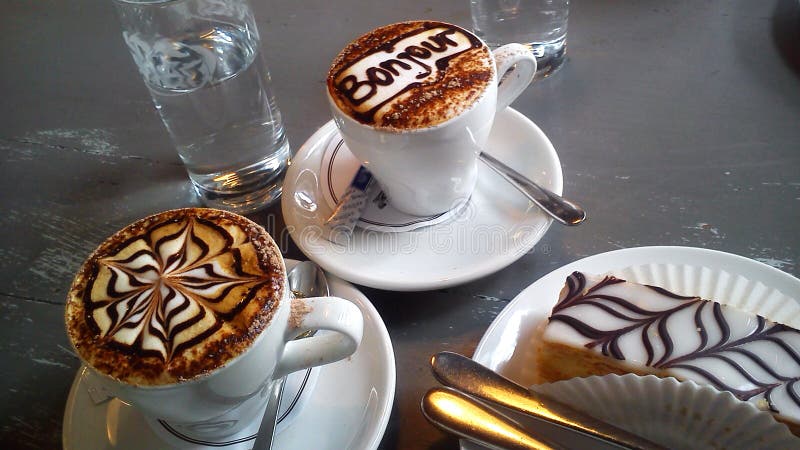 Arte del Latte Dos tazas de cierre del capuchino para arriba foto de archivo libre de regalías Arte del Latte Dos tazas de cierre del capuchino para arriba foto de archivo libre de regalías