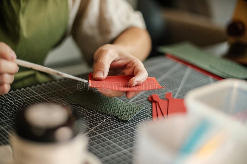 young leather craftsman working on crating leather product put on glue to merge leather pieces together. young leather craftsman working on crating leather product put on glue to merge leather pieces together