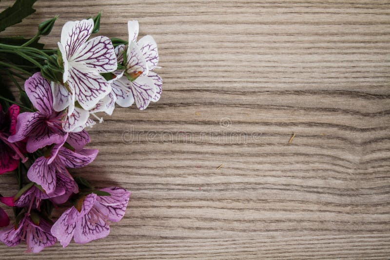 Articial-Blumen auf hölzernem Schreibtisch