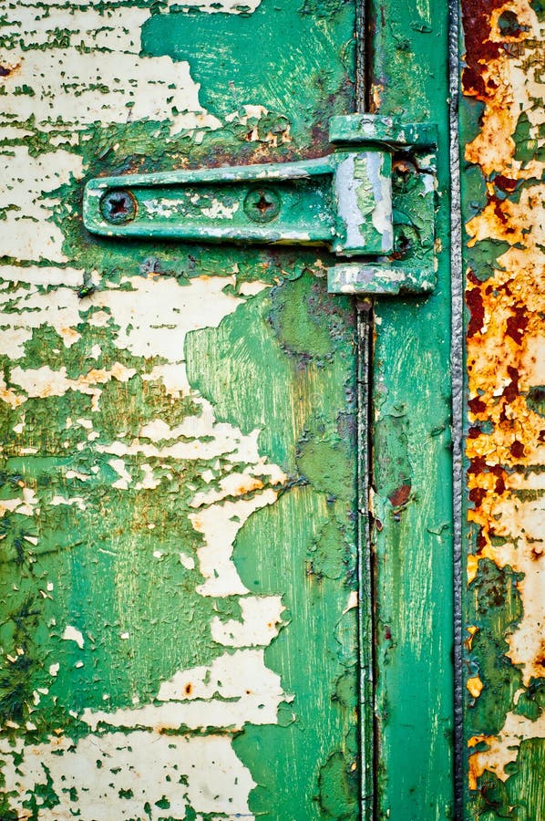 Hinge on rusty metal door. Textured door with cracked paint. Green painted door detail. Hinge on rusty metal door. Textured door with cracked paint. Green painted door detail.