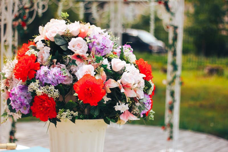 Artificial flowers on the street in white pot