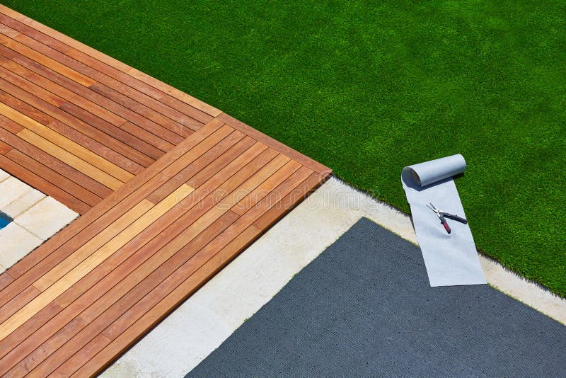 Artificial grass installation in deck garden with tools stock image