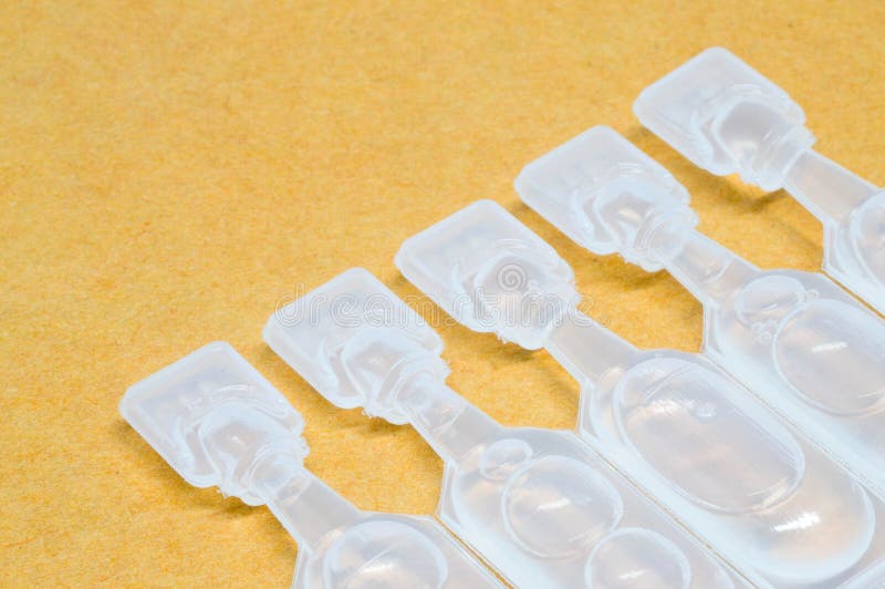 Artificial tear single use containers eye drop on yellow paper t royalty free stock image Artificial tear single use containers eye drop on yellow paper t royalty free stock image