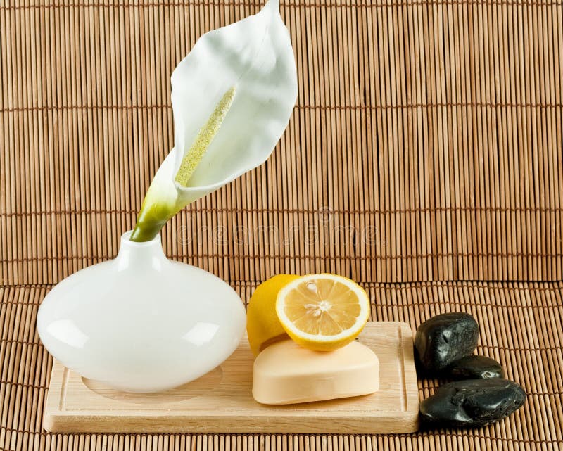 A decorative display of skin care items including natural soap, lemons, black spa stones and a peace flower blossom. A decorative display of skin care items including natural soap, lemons, black spa stones and a peace flower blossom.