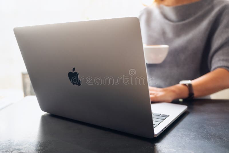 Mar 11th 2021 : A woman using and working on Apple MacBook Pro laptop computer while drinking coffee, Chiang mai Thailand. Mar 11th 2021 : A woman using and working on Apple MacBook Pro laptop computer while drinking coffee, Chiang mai Thailand