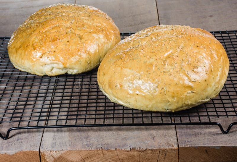 Artisan rosemary bread on cooling rack royalty free stock photography