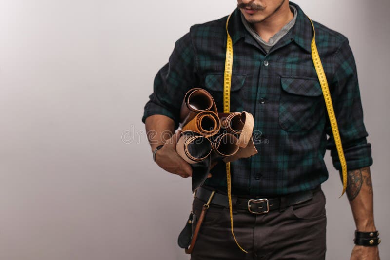 Artisanaal van leer in het creatieve zwarte hoed stellen met leergoederen in studio stock fotografie Artisanaal van leer in het creatieve zwarte hoed stellen met leergoederen in studio stock fotografie