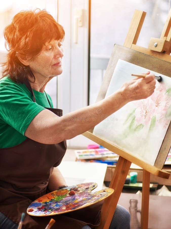 Artist painting easel in studio. Authentic senior woman. stock photos Artist painting easel in studio. Authentic senior woman. stock photos
