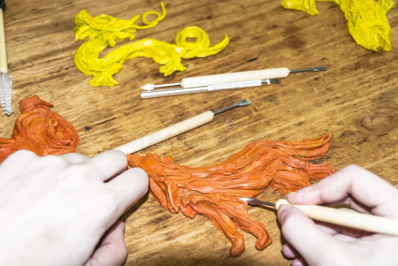 Artist`s Hands cut and modeling of animal figures of clay and plasticine instruments