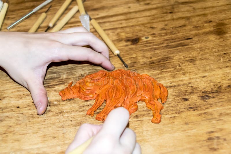 Artist`s Hands cut and modeling of animal figures of clay and plasticine instruments