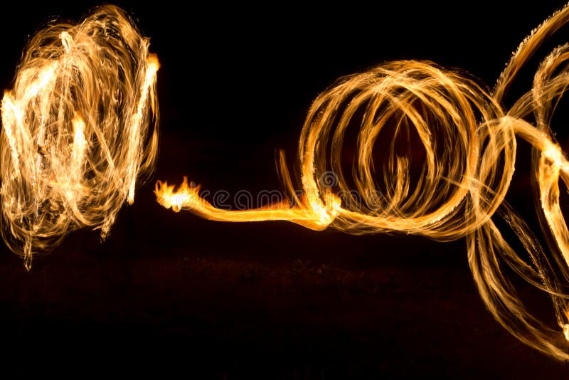 The Artist Shows a Fire Show at Night Spinning Torches, Circles of Fire and Loops Stock Image