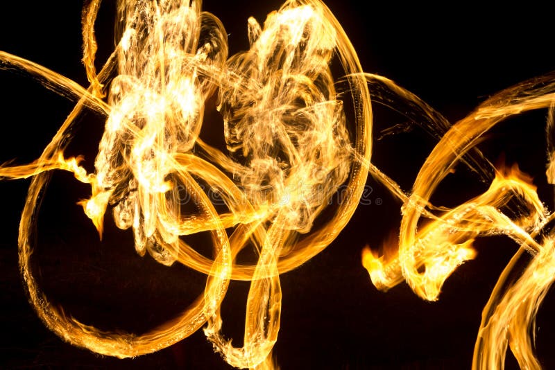 The Artist Shows a Fire Show at Night Spinning Torches, Circles of Fire and Loops Stock Image