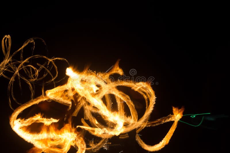 The Artist Shows a Fire Show at Night Spinning Torches, Circles of Fire and Loops Stock Photo