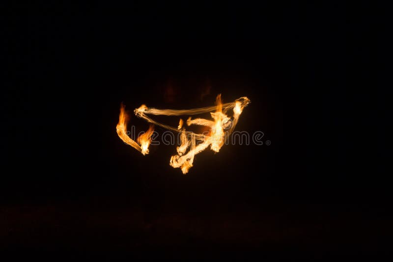 The Artist Shows a Fire Show at Night Spinning Torches, Circles of Fire and Loops Stock Image