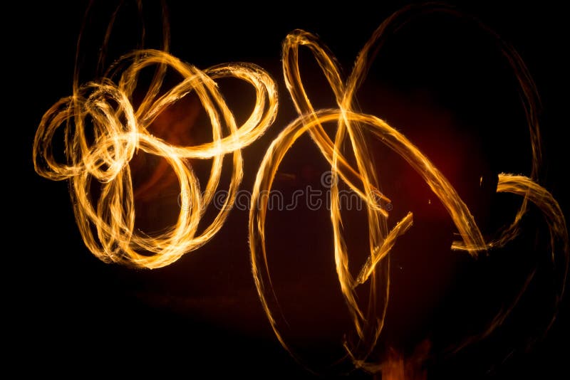 The Artist Shows a Fire Show at Night Spinning Torches, Circles of Fire and Loops Stock Image