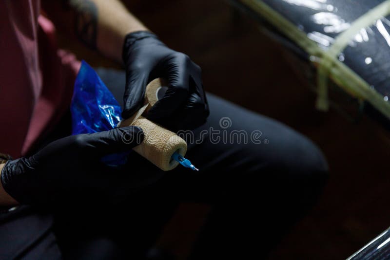 Artista da tatuagem que faz a tatuagem no salão de beleza do tatoo O mestre faz a tatuagem no estúdio da tatuagem imagens de stock Artista da tatuagem que faz a tatuagem no salão de beleza do tatoo O mestre faz a tatuagem no estúdio da tatuagem imagens de stock