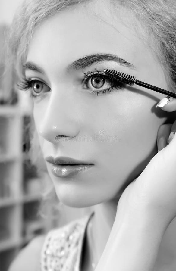 Artista de composição que aplica o rímel no olho do modelo fotos de stock Artista de composição que aplica o rímel no olho do modelo fotos de stock