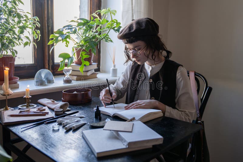 Artiste féminine engagée et réfléchie crée des croquis à l'aide de stylo et de pinceaux dans un bloc-notes. travail indépendant photographie stock libre de droits