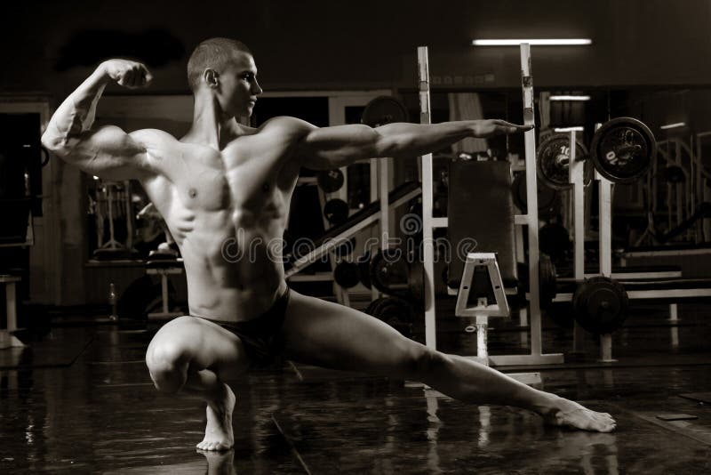 Artistic bodybuilder training shot of young muscular man in the gym