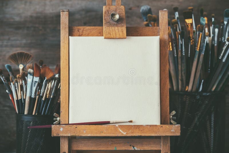 Artistic equipment in a artist studio: empty artist canvas and brushes.