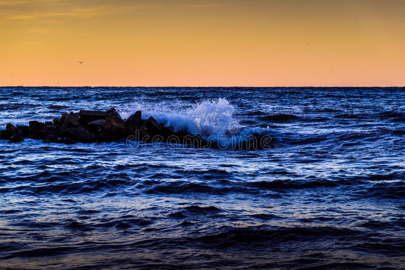 Artistic and elegant blue waves with orange colored hazy sky and deep horizon upon Marmara sea of country Turkey. Artistic and elegant blue waves with orange colored hazy sky and deep horizon upon Marmara sea of country Turkey.