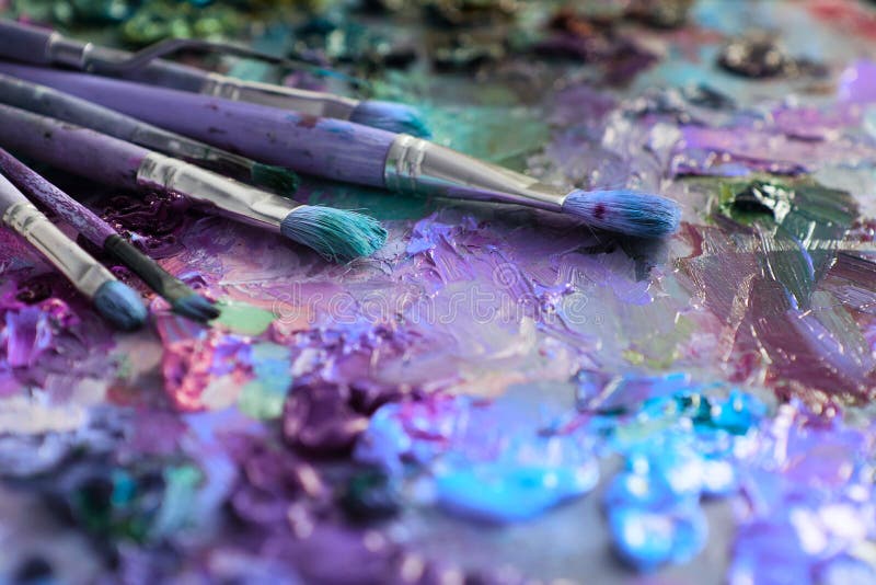 Artists brushes and oil paints on wooden palette