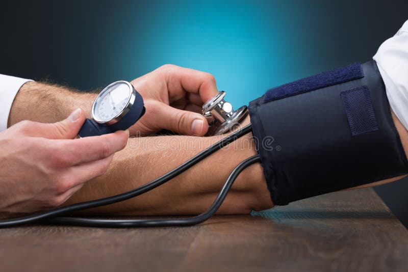 Arts Checking Blood Pressure van Patiënt bij Lijst