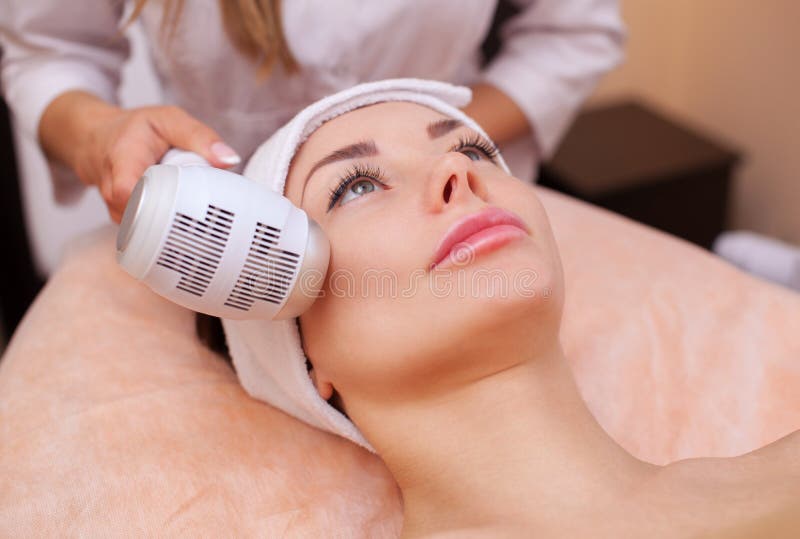 Arts-cosmetologist maakt de procedure Cryotherapy van de gezichtshuid van een mooie, jonge vrouw in een schoonheidssalon royalty-vrije stock afbeelding Arts-cosmetologist maakt de procedure Cryotherapy van de gezichtshuid van een mooie, jonge vrouw in een schoonheidssalon royalty-vrije stock afbeelding